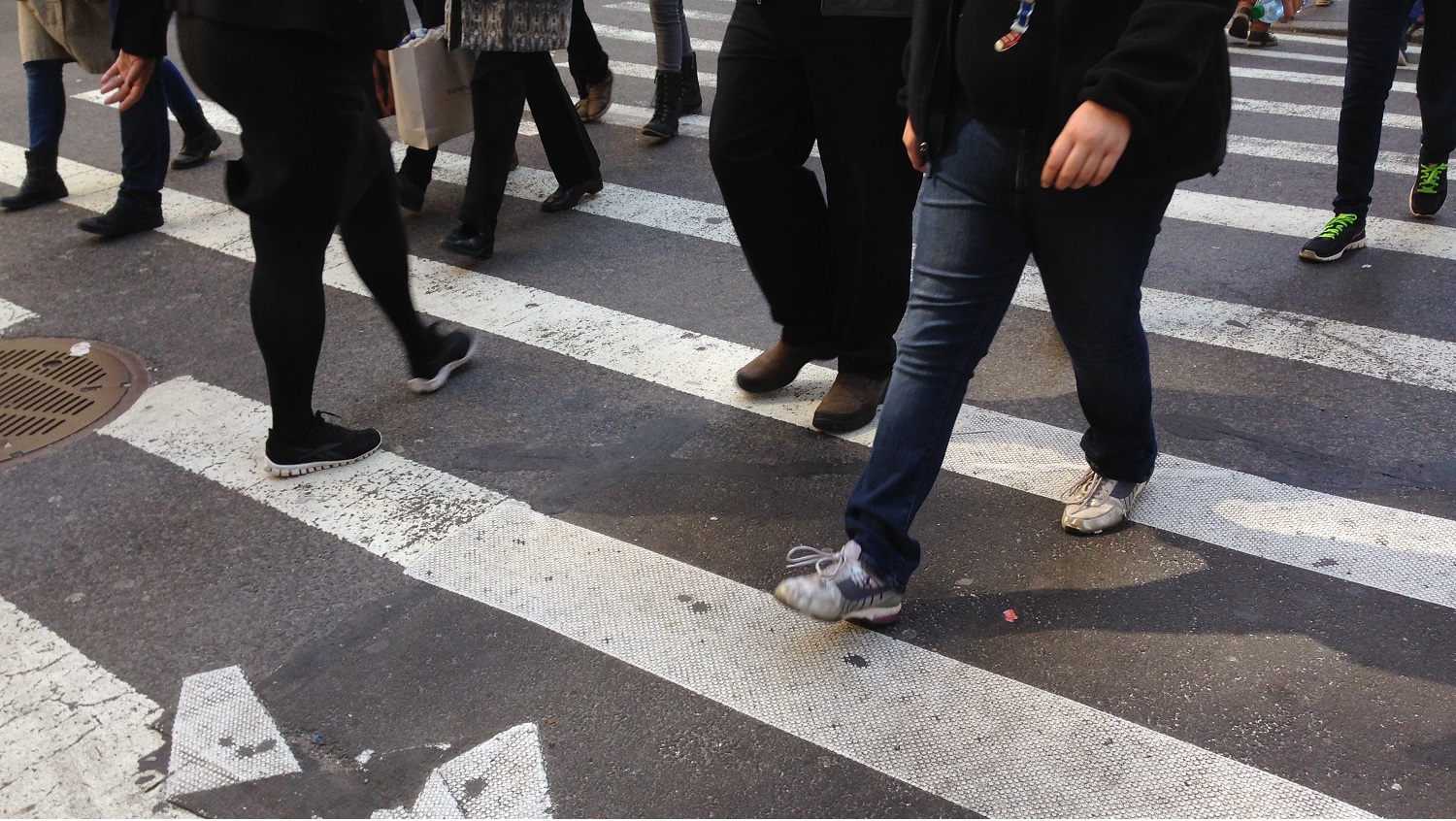 Pedestrians crossing city sidewalk